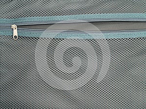 open zipper inside suitcase with green mesh texture background