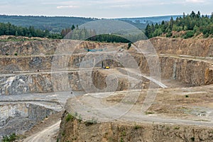 Opencast mining quarry with machinery. Quarrying of stones for c
