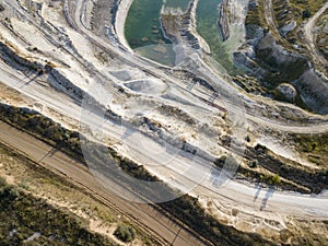 Opencast mining quarry with machinery at work - Aerial view. Industrial Extraction of lime, chalk, calx, caol