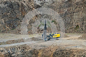 Opencast mining quarry with mining drilling machine.
