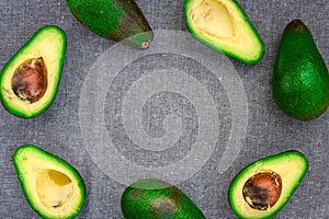 Opened avocado showing seed on textured grey linel background. Top view, Copy space