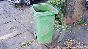 Opened big empty green plastic trash garbage bin. Public trash bin.