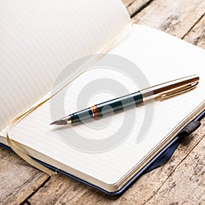 Opened blank notebook with elegant fountain pen