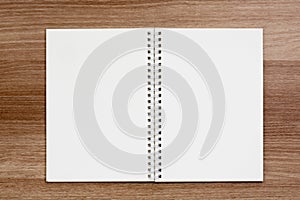 Opened blank ring spiral binding notebook on wooden surface