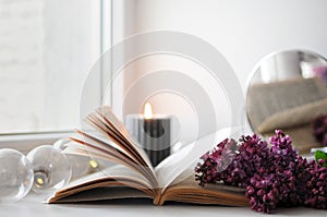 Opened book with flowers. Cozy spring atmosphere at home. Blooming lilac