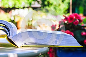 Opened book on table in summer garden