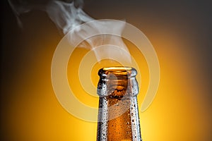 Opened bottle of cold beer and gas output isolated on a yellow background