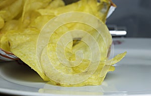 Opened chips bag and porcelain plate underneath