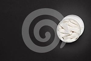 opened container with snus nicotine white bags on a dark background. copy space for design