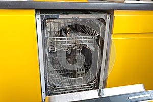 Opened dishwasher in the yellow kitchen