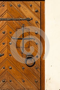 Opened door with ancient style carved knocker
