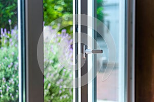 Opened door of a family home. Lock of the sliding door with the yard of background.