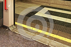 Opened doors of London underground tube  train with yellow line on ground