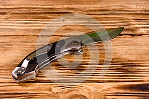 Opened folding knife on a wooden table