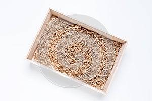 Opened gift wooden box with shredded paper filler on white background for product placement