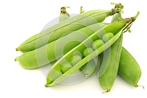 Opened green pea pods with peas visible