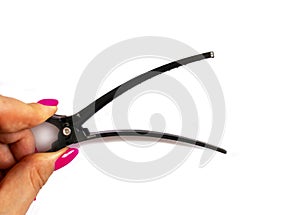 Opened hair clip in woman hand  on white background. Black hair clip.
