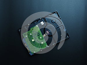 Opened hard drive disk on dark background.
