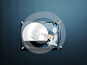 Opened hard drive disk on dark background.