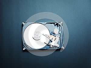 Opened hard drive disk on dark background.