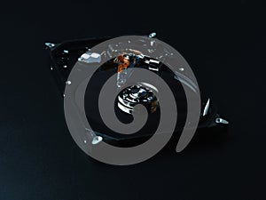 Opened hard drive disk on dark background.