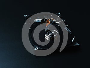 Opened hard drive disk on dark background.