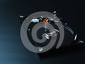 Opened hard drive disk on dark background.