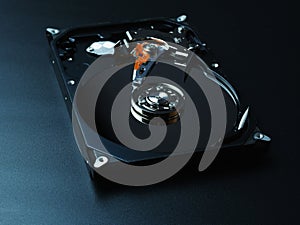 Opened hard drive disk on dark background.
