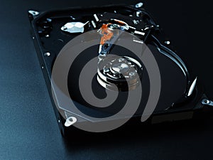 Opened hard drive disk on dark background.