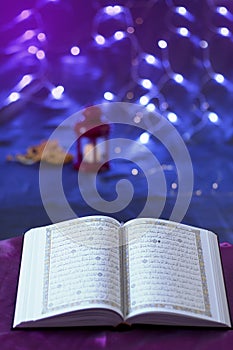 Opened HOLY Quran on silky fabric bokeh background