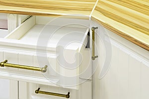 Opened kitchen drawer, kitchen in a modern neoclassicism style with wood top and white fronts
