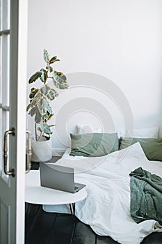 Opened laptop in scandinavian modern cozy bright interior in bedroom at home