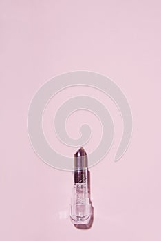 Opened lipstick on pink background.