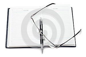 Opened notebook with pen and glasses