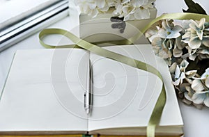 Opened Notepad with handle, flowers, ribbon, casket, place for inscription