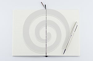 Opened notepad with pen on white background.