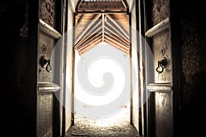 Opened old ancient temple door gate with radiance light with effect of light at the end of the tunnel