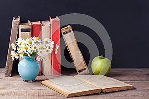 Opened old vintage book lies on a wooden rustic table. Country still life.