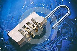 Opened padlock on computer motherboard. Internet data privacy information security concept. Blue toned image