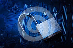 Opened padlock on computer motherboard. Internet data privacy information security concept. Blue toned image