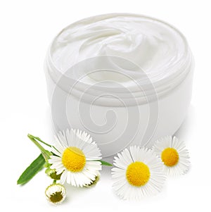 Opened plastic container with cream and camomile.