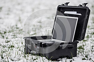 Opened plastic protector case with laptop lying on the grass an