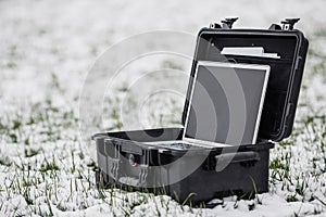 Opened plastic protector case with laptop lying on the grass an