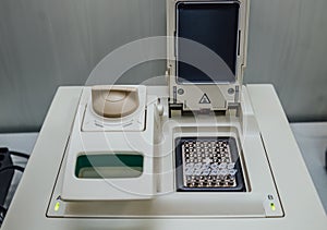 Opened polymerase chain reaction PCR cycler machine with DNA samples