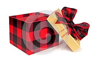 Opened red and black buffalo plaid Christmas gift box with lid and bow isolated on white