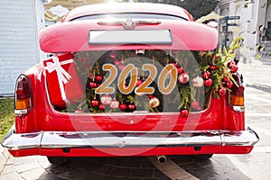 An opened red car trunk filled with cloth bags full of gifts and decorations for Christmas. Happy New Year. 2020