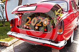 An opened red car trunk filled with cloth bags full of gifts and decorations for Christmas. Happy New Year. 2020