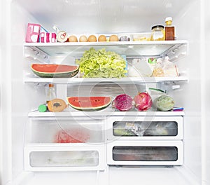 Opened refrigerator full of products inside