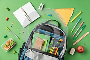 Opened school backpack with stationery