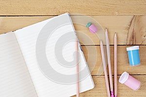 Opened School Notebook And Various Stationery. Back To School Concept. Notebook, Scissors, Painting Paints, Pencils On Wooden